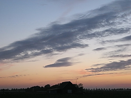 De paardenschuur van Jan Tempel als baken in het landschap ten westen van Noordhorn. De grillige lucht met de suggestie van oneindigheid....