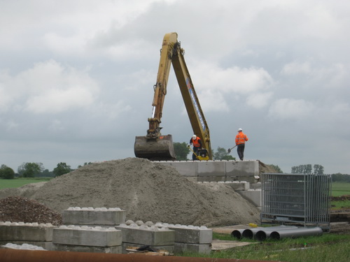 Een kraanmachinist en twee oranje hesjes, gestaag bezig... Wordt hier een van de brughoofden gerealiseerd?