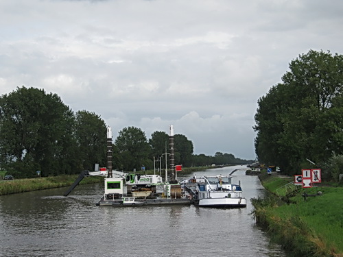 Baggerbeeld vanaf de brug tussen Noord- en Zuidhorn, aan de oostkant. Het werkeiland in het midden, de grondboot er rechts naast. Links blijft een smalle strook voor de binnenvaart...