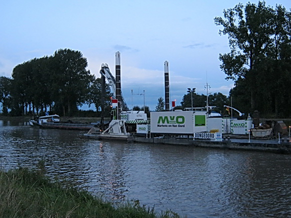 Een van de werkplekken van Martens & Van Oord. Het drijvende werkeiland (noem je dit ook een ponton?) met de kraan. Een modderschuit ernaast, in dit geval de "Orion". 