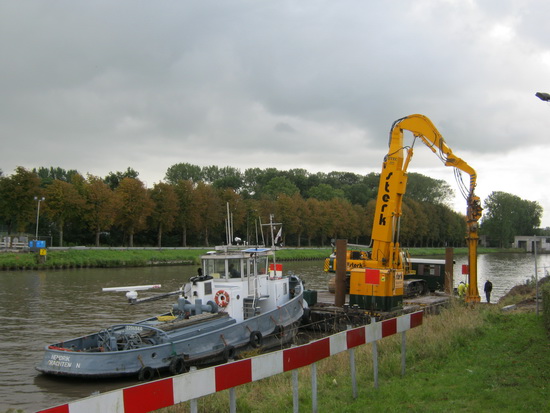 De trouwe "Hendrik" uit Drachten houdt een oogje in het zeil, is stand-by.  Aan de overkant zijn de platen ook al in de kanaalwand geheid.