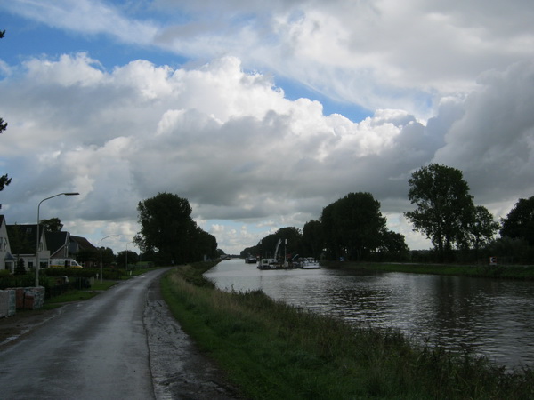 Aan de oostkant van de brug, net na de regenbui, is het ook een en al activiteit. Baggeren op de voorgrond, lossen verder naar het oosten bij de plek van de nieuwe brug.