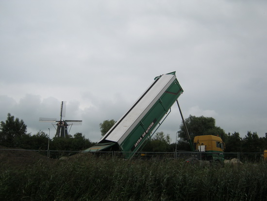 Nog meer vrachtwagenactiviteit.... Hier een speciale vrachtauto met een bijzondere lading, bedoeld als ondergrond voor de omleidingsweg. Gemalen puin? Tussenlaag tussen zand en asfalt?