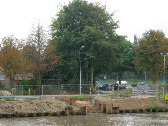 De overkant aan de zuidelijke oever van het Van Starkenborghkanaal, bij het oude gymgebouw aan de Westergast. Ook daar zie je de plek waar de gasbuis wordt verzonken en aangesloten.
