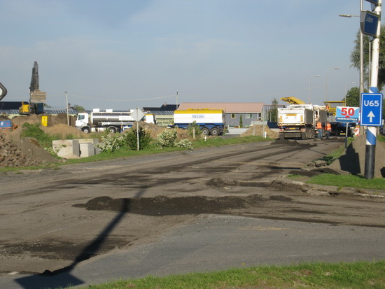 Als je je blik noordwaarts richt (en waarom zou je dat niet doen?), zie  en hoor je een drukte van belang. (Je ruikt het zelfs...) Ook van dit N355-gedeelte wordt het dek verwijderd en afgevoerd.