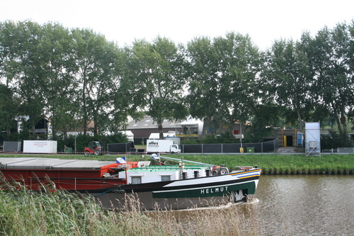 In het Van Starkenborghkanaal vaart "Helmut", aan de overkant begint KANAALPOP bij jeugdcentrum "Avalon"....We fietsen gelijk op met Helmut.....