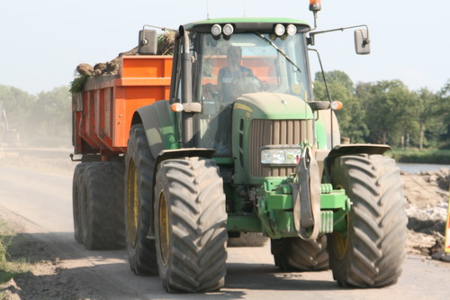 De forse tractoren met hun kiepwagens rijden af en aan, zij veroorzaken de fraaie stofwolken in dit droge jaargetijde....