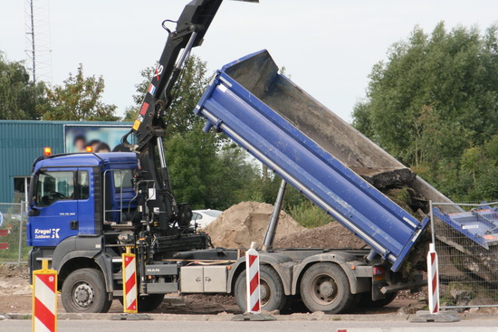 Een vrachtwagen lost de brokken plaveisel schuin aan de overkant; zullen daar later wel weer door een andere vrachtwagen worden opgehaald....