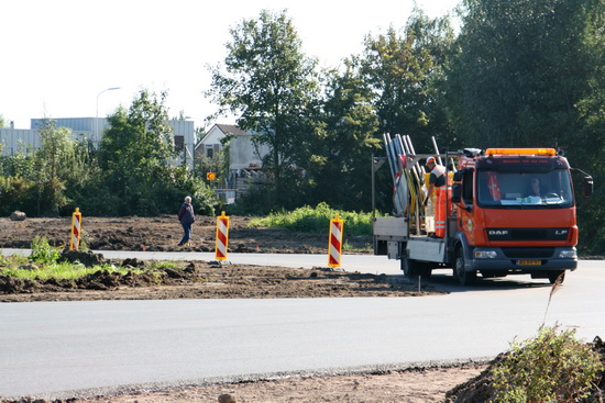 Enkele medewerkers, met helm, bezig de omleidingsweg gebruiksklaar te maken. En links, wie zien we daar? Waarnemer Jan Thijs de Haan, van de Langestraat Zuid. "Waar is je helm, Jan Thijs???!"