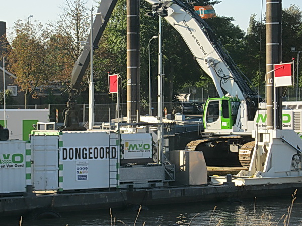 Naast het werkeiland van Martens en Van Oord ligt een baggerschuit te wachten, en te 'ontvangen': Zo te zien nogal waterige happen....