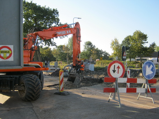 Complicerende werkzaamheden aan de kop van de parallelweg. Een grijper doet zijn werk en verspert tegelijkertijd de doorgang voor de auto's die hier toch nog langs willen. En desnoods maar over de berm rijden.... 'k Heb trouwens wel het idee dat vele van deze auto's beter langs de Langestraat Noord zouden kunnen gaan...
