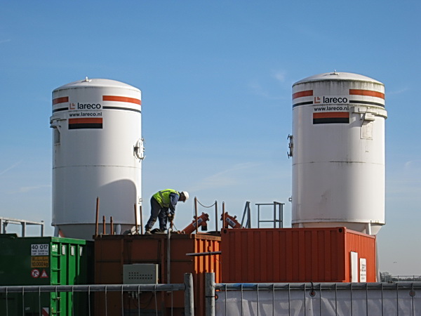 Daar waar Langestraat 9 en 11 troonden, staan nu o.a. betonsilo's. Daartussen is een GMB'er aan het werk. Nee, hij gaat geen vuurpijl afsteken, dat lijkt alleen maar zo...