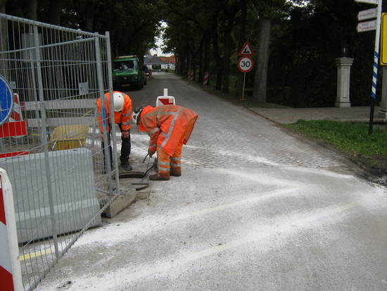 De putmensen zijn bezig hun geluk bij een ander gat te beproeven. Let op de routeaanduiding van de fietsstrook! 