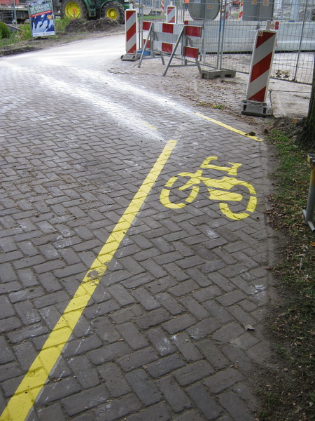 Terug bij de Langestraat Zuid, waar de vrachtauto is verdwenen en de gele fietsstrook nu voor iedereen zichtbaar is....