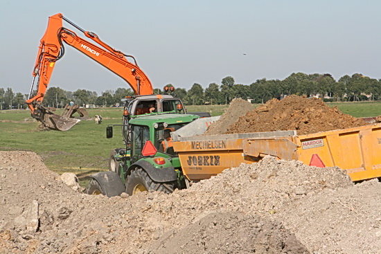 De dragline op de achtergrond, er schuift een tractor met grondkar van Mechielsen tussen bult en grijper....