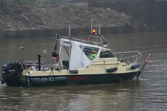 Een van de belangrijke deelnemers aan het zaterdagspektakel, de peilboot met deskundigen van de Gasunie aan boord. Zij geven aan of de gecreëerde sleuf op de kanaalbodem optimaal geschikt is om de tweelingbuizen te 'ontvangen'. Zo niet? Baggeraar op herhaling...
