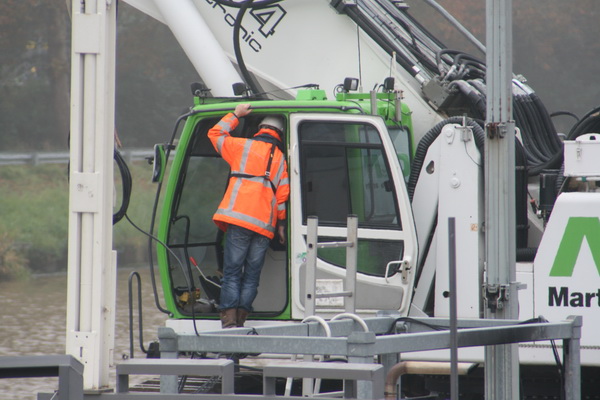 De contactman doet zijn naam eer aan en gaat even communiceren met de kraanmachinist. (Volgens een deskundige aan de wal mag dit trouwens niet, staan en praten in de opening van de cabine....)