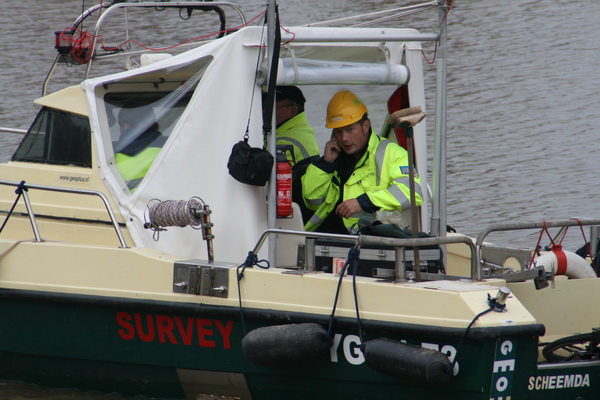 Een lid van het peilteam op de drijvende Geo Spider. Er is blijkbaar eindoverleg nodig met een buiten-beeld-instantie. Wie neemt de beslissing?