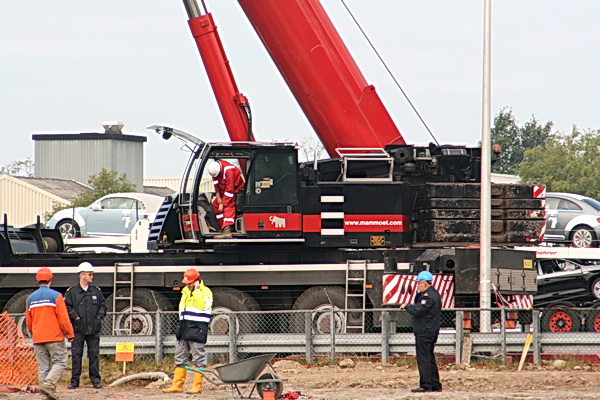 Hier wordt het nog duidelijker. Ineens bedrijvigheid alom. De kraanmachinist gaat de cabine in, er wordt nog gebeld, de meeste wachtenden zijn al op hun post elders. Alleen de veiligheidsbeambte kan zijn handen in zijn zakken houden....