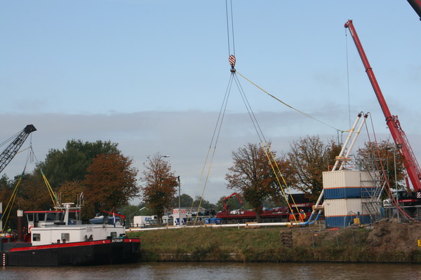 Hier kun je nog eens goed zien hoe de tweelingbuizen met de uiteinden omhoog aan de noordkant van het kanaal liggen. Vastgemaakt aan enerzijds de kraanboot "Redbad" uit Jutrijp en anderzijds de mammoetkraan van Wagenborg. Tillen en een kwartslag draaien....