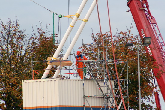Deze oranjerode werker heeft een functie bovenop het oostelijke containerblok. Los of vast?