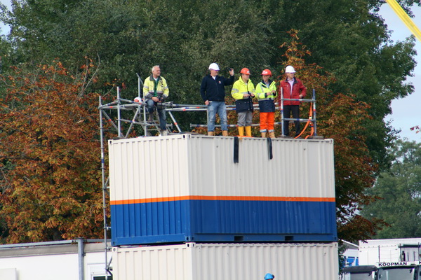 Bovenop het andere containerblok is een VIP-tribune ingericht. Er is er zelfs eentje bij die vanwege de spanning de helm heeft afgezet, dat is eigenlijk tegen de regels!