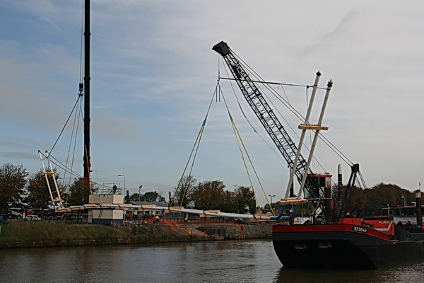Zover zijn we! De buizen hangen boven het water van het Van Starkenborghkanaal. NU nog opschuiven in oostelijke richting, naar de inhammen in de kanaaloevers. De "Redbad"  vaart heel voorzichtig, de Mammoetkraan van Wagenborg beweegt heel voorzichtig mee...