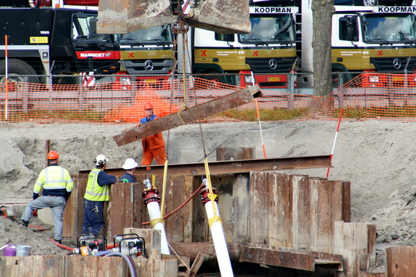O, dat gaat er gebeuren: Een van de ijzeren balken bovenop wordt met de happer van de dragline op het werkeiland "Dongeoord" opgetild en....