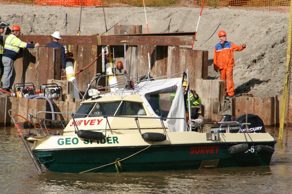 De betrokkenen op de peilboot willen ook wel eens van nabij zien wat de kraanmachinist kan verhapstukken. De westelijke balkenwand iets achteruit duwen?