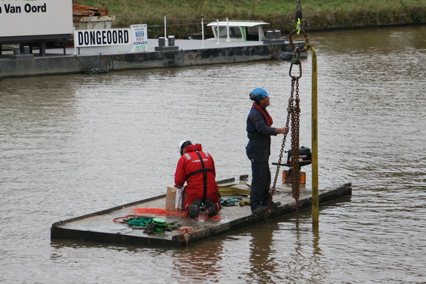 Mooi gezicht, dit gehelmde duo op het vlot met buitenboordmotor. Nee, een nat pak zit er niet in....
