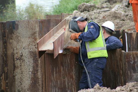 Bij de ijzeren balken aan de zuidkant wordt intussen laswerk verricht. De boel moet onwrikbaar vast blijven zitten....