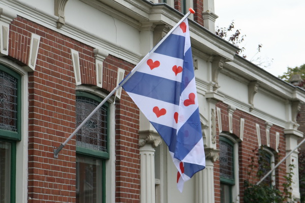 Verderop, in het middengedeelte van de Langestraat, drie bijzondere vlaggen... Nee, niet de Friese, maar de Ommelander vlag! Met harten! (En geen plompebledden of pompebledden...) En: De Ommelander vlag is ouder dan de Friese!!!