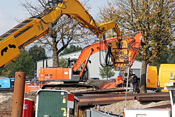 De arm van het hei-apparaat verzoekt aan de werker op de kant een nieuwe plaat vast te maken....