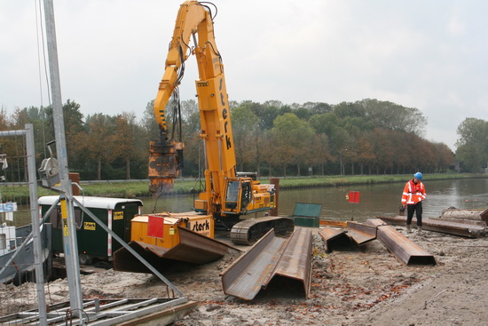Hier vindt het heiwerk plaats, maar ook het uit de bodem trekken van vergelijkbare platen. Allemaal voor de beschoeiing? Of worden er ook platen op een bultje bij elkaar geplaatst, in afwachting van toekomstige activiteiten? Het weghalen van de oude leidingen bijvoorbeeld, als de nieuwe in gebruik zijn...