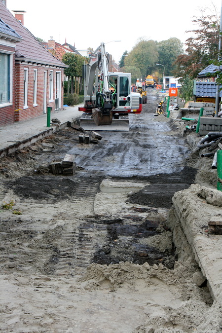 Een paar stappen naar voren en dan is de staat van de Noorderweg beter te beoordelen. Het middengedeelte wordt klaargemaakt voor het asfalt, aan de randen worden de kantstenen gelegd.