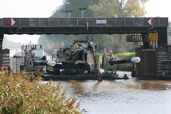 Hier gaat het gevaarte onder de tafelbrug door, het past. Ruim! Met die neergelaten pijpen heeft het eiland wel iets van een drijvend fort met kanonnen....