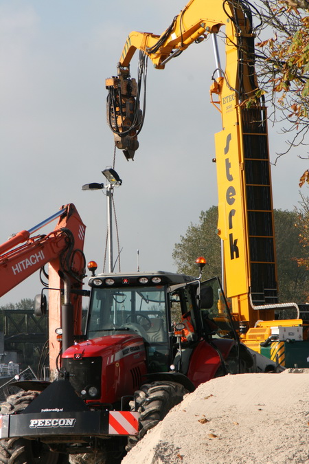 De oranje alleskunner staat nu op de vaste wal en verricht allerlei hijs- en verplaatsklusjes. Zo te zien gaan de vogelvriendelijke lampen ook naar elders...