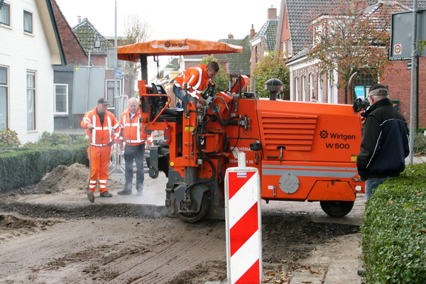 Weer zo'n indrukwekkend apparaat met knoppen, hendels, slangetjes etc.  De bijsnijder.... De oude rand wordt gedegen bijgesneden, zodat de nieuwe laag er bijna naadloos tegenaan wordt gevlijd.