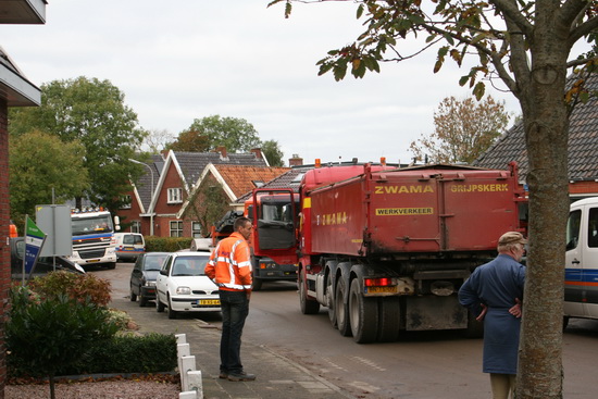 Verkeersproblemen in de Langestraat, waar "even"  geen doorkomen aan was. Asfaltauto, aanvoerauto van apparaten, geparkeerde auto's: "Woar mout ik nou din laangs??!"