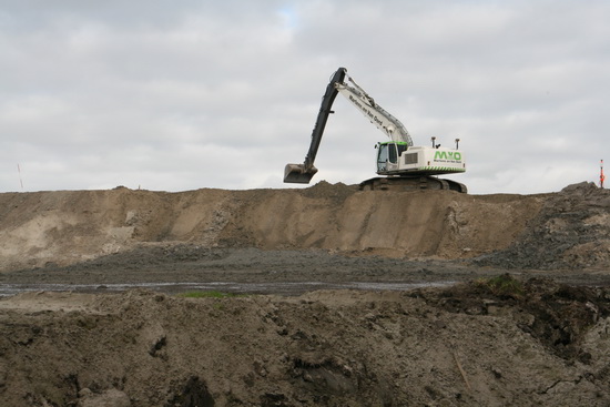 Ook de witte dragline van Martens en Van Oord werkt op niveau. Er  worden heel wat kubieke meters verwerkt, voordat de weg daadwerkelijk kan worden aangelegd. Geeft toch een dubbel gevoel: Bewondering voor het nieuwe,  maar het veranderende landschap wordt er niet mooier op....