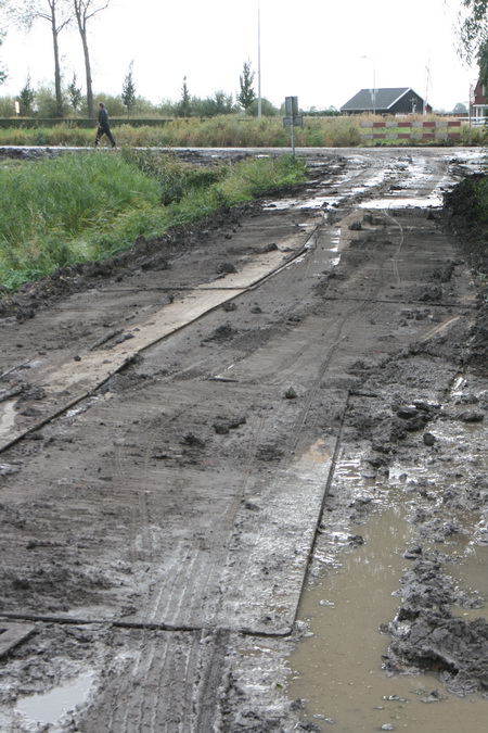 Het gedeelte van de Mokkenburgweg van kanaal naar viaduct achter de boerderij langs. Bemodderde rijplaten, het gaat net goed....