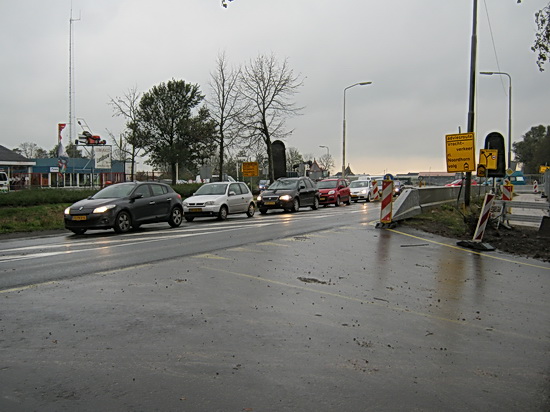 Voor voetgangers en fietsers blijft dit een gevaarlijke plek op de parallelweg. Er kan zo maar een auto de hoek om komen... Ja, nu even niet, brug omhoog... File....