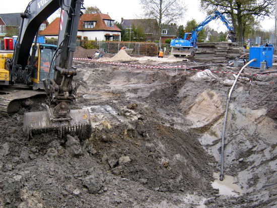 Duidelijk in beeld, de werkenden zijn terug! En de kuil wordt gestaag groter en dieper..... (Of wordt er toch voorzichtig gemanoeuvreerd? Daarom de ene grijper die de grond los maakt en op een andere plaats deponeert... Daarna de tweede grijper die de karren (met dubbeldikke banden) vult....
