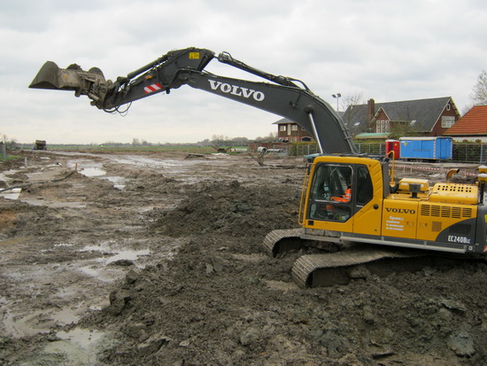De draglinemachinist gooit een schep vol grond op een plek verderop. Net of hij even wuift of wijst met zijn grijperarm....