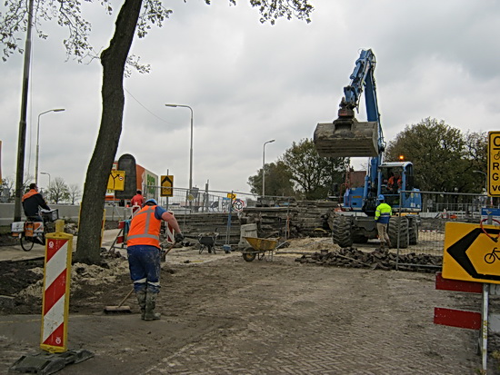 Hier is een doener bezig, de nieuwe bestrating bij het omleidingspad voor fietsers is klaar, even aanvegen nog. 