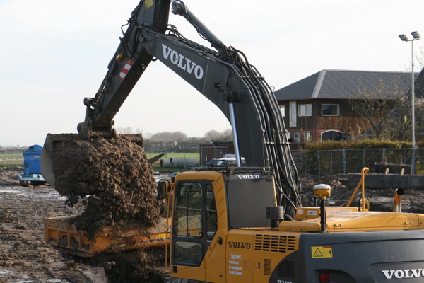 Hier wordt zo'n grote hap in de laadbak van het rupswagentje gelegd. Drie happen en het wagentje 'rupst' zijn lading oostwaarts. Gaat efficiënter dan met de brede-bandenkar+tractor...