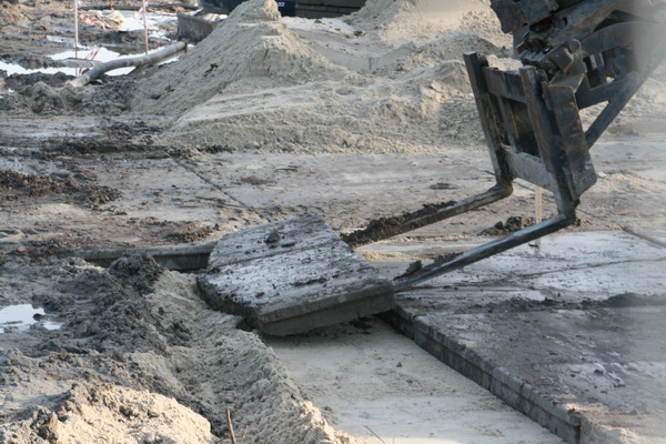 Andere activiteit aan de zuidkant van het terrein. De "blauwe kapitein" is met zijn GMB-grijper bezig betonplaten goed te leggen, tot aan de rand van de tunnelkuip...